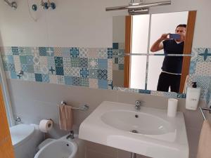 a man taking a picture of a bathroom mirror at BlancheMarie in Agropoli