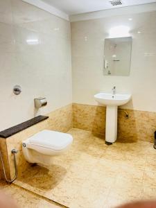 a bathroom with a toilet and a sink at Hotel Grand Bee , Yeshwanthpur Junction in Bengaluru