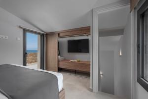 een slaapkamer met een bed en een glazen schuifdeur bij Blue Haven Villa in Polykhrono