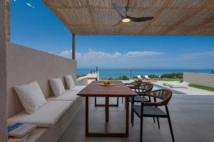 een woonkamer met een bank, een tafel en stoelen bij Blue Haven Villa in Polykhrono