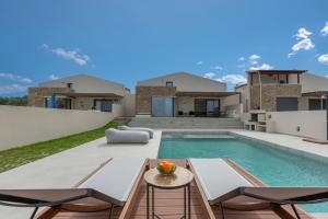 een achtertuin met een zwembad en een villa bij Blue Haven Villa in Polykhrono