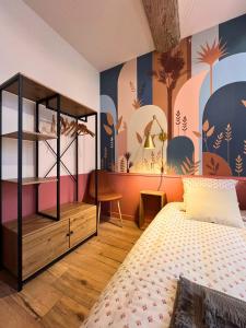 a bedroom with a bed and a wall with a mural at Le secret du Damier by Miss K in Mâcon