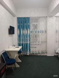 a room with a desk and chairs and a curtain at Айымхан in Almaty +4 photos