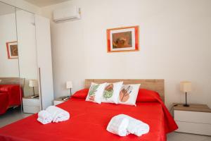 een slaapkamer met een rood bed en handdoeken erop bij Lemon Riviera Casa Vacanze in Massa Lubrense