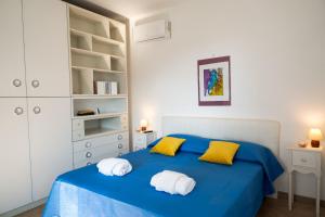 een slaapkamer met een blauw bed met gele kussens bij Lemon Riviera Casa Vacanze in Massa Lubrense