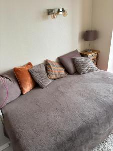 ein Bett mit einem Haufen Kissen drauf. in der Unterkunft Studio op achtste verdieping op de zeedijk met fenomenaal zeezicht voor 2 personen in Middelkerke