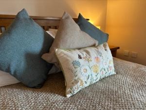 a group of pillows sitting on top of a bed at The Shippon Barn - A delightful haven for families in Wirral