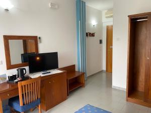 a room with a desk with a computer and a mirror at Hotel Villaggio Aurora in San Pietro in Bevagna