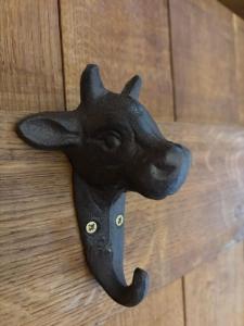 a black door knocker of a dog head on a wooden door at The Shippon Barn - A delightful haven for families in Wirral
