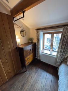 a bedroom with a window and a dresser and a bed at The Shippon Barn - A delightful haven for families in Wirral