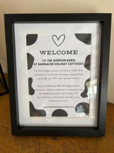 a framed picture of a welcome to the shower man at banquet holiday center at The Shippon Barn - A delightful haven for families in Wirral