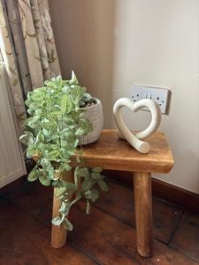 a table with a plant and two swans on it at The Shippon Barn - A delightful haven for families in Wirral