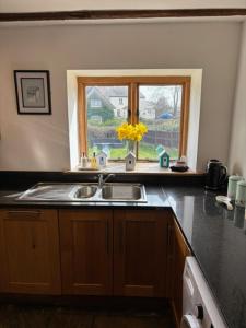 a kitchen with a sink and a window at The Shippon Barn - A delightful haven for families in Wirral