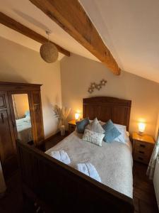 a bedroom with a large bed with blue pillows at The Shippon Barn - A delightful haven for families in Wirral