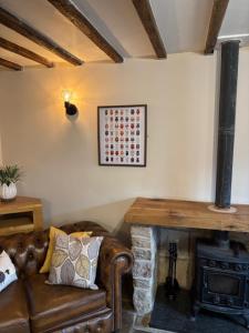 a living room with a couch and a wood stove at The Shippon Barn - A delightful haven for families in Wirral