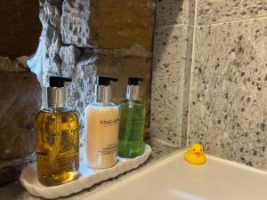 two bottles of soap and a rubber duck on a bathroom sink at The Shippon Barn - A delightful haven for families in Wirral