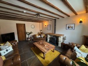 a living room with leather furniture and a fireplace at The Shippon Barn - A delightful haven for families in Wirral