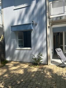 a chair next to a building with a window at appartement T3 très fonctionnel et central au Cap Ferret in Cap-Ferret