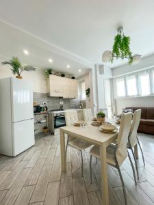 a kitchen and dining room with a table and a white refrigerator at Home In Town - Fiera Milano City near San Siro Stadium metropolitana M1 - M5 in Milan