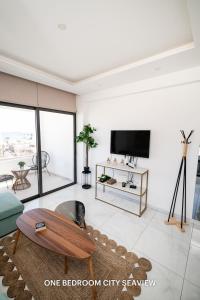 a living room with a coffee table and a tv at Lazuli Seaview Apartments 2Bdr in Larnaka