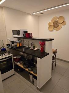 a kitchen with a counter with a sink and a stove at 100m da praia de Copacabana in Rio de Janeiro