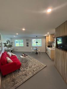 a living room with a red couch and a tv at Window to Paris Studio on Lake Conroe in Montgomery