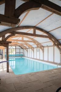 a large indoor swimming pool with a ceiling at The Shippon Barn - A delightful haven for families in Wirral