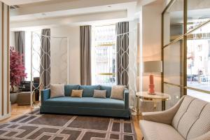 a living room with a blue couch and two chairs at Vincci Centrum in Madrid