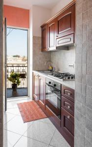 a kitchen with wooden cabinets and a large window at Marco Aurelio in Rome