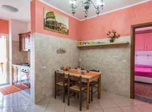 a kitchen with a table and a kitchen with pink walls at Marco Aurelio in Rome
