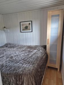 Un dormitorio con una cama y un cuadro en la pared. en Utsikten Bjerkøya, en Holmestrand