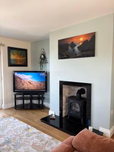 Il comprend un salon doté d'une cheminée et d'une télévision à écran plat. dans l'établissement Portrush West Strand, Seaviews, 2 balconies sleeps 6, à Portrush