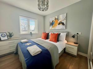a bedroom with a large bed with orange pillows at Swan House in Pallion