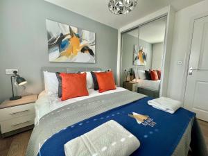 a bedroom with a large bed with orange pillows at Swan House in Pallion