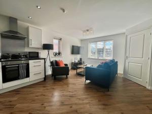 a living room with two chairs and a kitchen at Swan House in Pallion