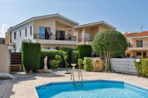 una villa con piscina frente a una casa en The Marilouize Apartment, en Peyia