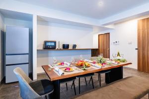 une salle à manger avec une table avec des fruits dessus dans l'établissement Walking distance to the beach & full of gourmet spots! Up to 8 people, free parking for 2 cars コーディアルステイA2, à Onna