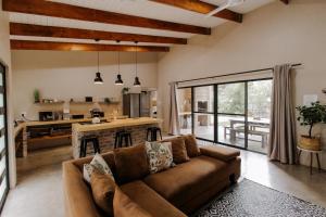 a living room with a couch and a kitchen at Afri Villa Stays - Luxury Bush Villa Hyena in Marloth Park