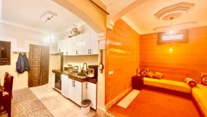 a kitchen with white cabinets and a yellow bench in a room at Edwiria Marrakech old Medina in Marrakesh