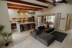 a living room with a couch and a kitchen at Afri Villa Stays - Luxury Bush Villa Bird in Marloth Park
