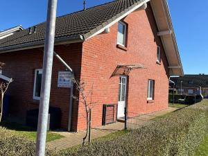 a red brick building with a white door at Ferienhaus in Hoben mit Grill und Terrasse in Zierow