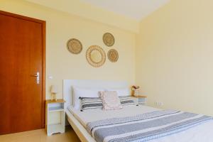 a white bedroom with a bed and a wooden door at Villa Momento by RentalsPro - Poseidi Halkidiki in Kalandra +42 photos