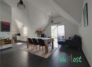 a dining room and living room with a table and chairs at Leu Sunset - Vue mer à 300m du lagon in Saint-Leu