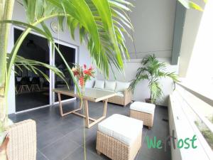 a patio with a table and chairs and plants at Leu Sunset - Vue mer à 300m du lagon in Saint-Leu