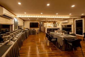 a restaurant with long tables and chairs and a kitchen at Vikash Eco Resort in Bālugān +10 photos