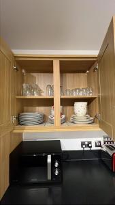 un placard avec des assiettes et des plats dedans dans l'établissement Alishan Cornwall Holidays sleep up to 6, à Newquay