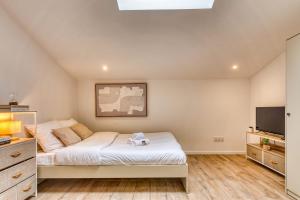 a bedroom with a bed and a flat screen tv at La Suite Sable - Cosy studio - Proche Métro B in Oullins
