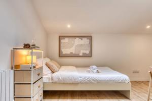 a small bedroom with a bed and a dresser at La Suite Sable - Cosy studio - Proche Métro B in Oullins +18 photos
