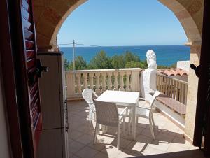 a balcony with a table and chairs and the ocean at casa dolce casa in Patù