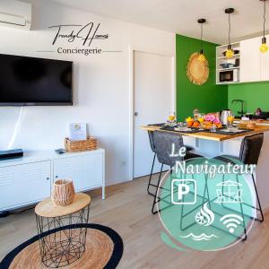 cocina con paredes verdes y barra con mesa en T2 - Terrasse - 3 min à pieds des plages- Parking privée - Clim - Wifi - 4 PAX, en La Grande-Motte